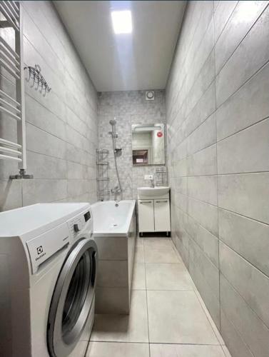 y baño con lavadora y lavamanos. en Apartament Loft na Ogrodowej, en Robakowo