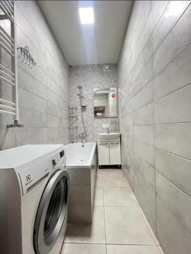 a bathroom with a washing machine and a sink at Apartament Loft na Ogrodowej in Robakowo