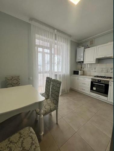 a kitchen with a table and two chairs and a counter at Apartament Loft na Ogrodowej in Robakowo
