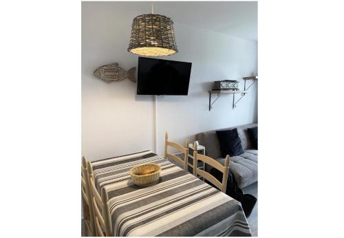 Cette chambre dispose d'une table, d'une télévision et d'un lit. dans l'établissement Port du Crouesty Cap'Océan - maeva Home - Appartement 2 pièces 4 personnes - Sélection - vue sur le Port MAE-1316, à Arzon