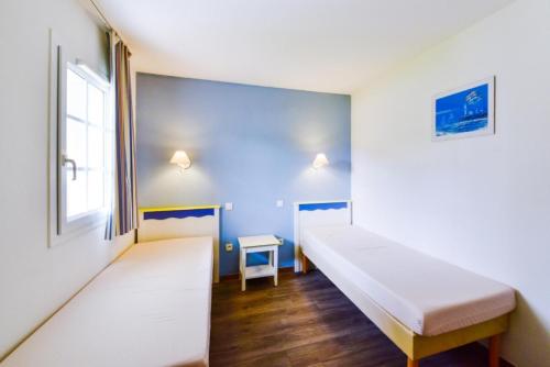 une chambre avec deux lits et une fenêtre dans l'établissement Port du Crouesty Cap'Océan - maeva Home - 2 Pièces 4 Personnes - Confort - vue sur le Port MAE-1315, à Arzon