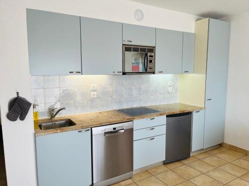 a kitchen with white cabinets and a sink at Hapimag Apartments Antibes in Antibes