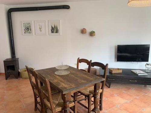 埃爾波索德洛斯弗萊爾斯的住宿－Cala San Pedro，一间带桌椅和电视的用餐室