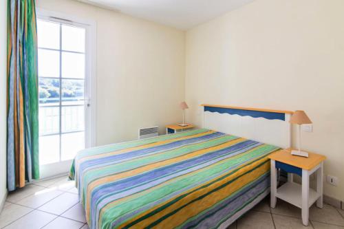- une chambre avec un lit doté d'un couvre-lit rayé coloré dans l'établissement Résidence Port Bourgenay - maeva Home - 2 Pièces 7 Personnes Sélection MAE-1442, à Talmont-Saint-Hilaire