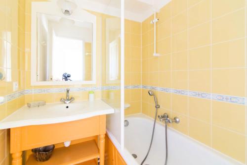 une salle de bain avec un lavabo, une baignoire et un miroir dans l'établissement Résidence Port Bourgenay - maeva Home - 2 Pièces 7 Personnes Sélection MAE-1442, à Talmont-Saint-Hilaire