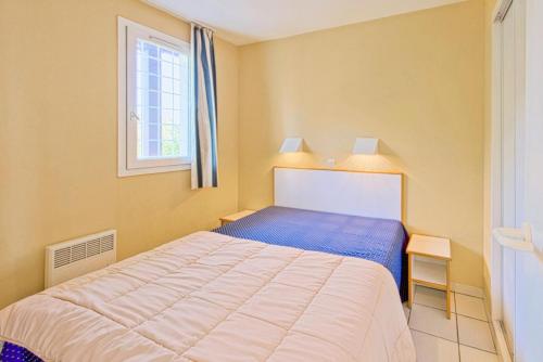 une chambre avec un lit et une fenêtre dans l'établissement Résidence le Hameau de Cap Esterel - maeva Home - Appartement 2 Pièces 7 Personnes - Sélection MAE-1473, à Saint-Raphaël