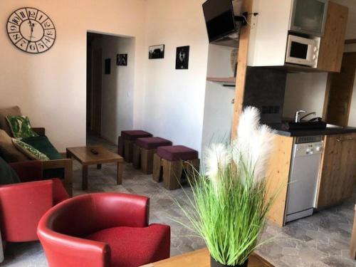 Il comprend un salon avec des chaises rouges et une cuisine. dans l'établissement Résidence Antares - Pièces 064, à Risoul