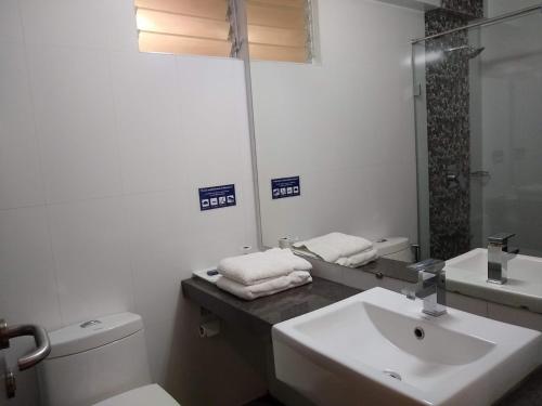 a bathroom with a sink and a toilet and a mirror at HOTEL THE SENTOSA in Rajkot