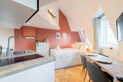 a kitchen and living room with a bed and a table at Lille center equipped studio in Lille