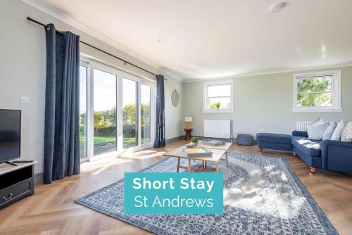 a living room with a couch and a tv at Firthview - Crail in Anstruther