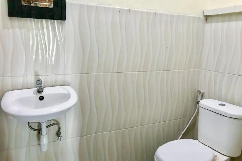 a bathroom with a toilet and a sink at Kampung Coklat Jembrana Mitra RedDoorz in Jembrana