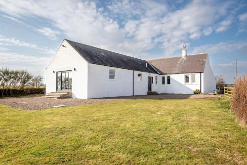 a white church with a grassy yard in front of it at Firthview - Crail in Anstruther