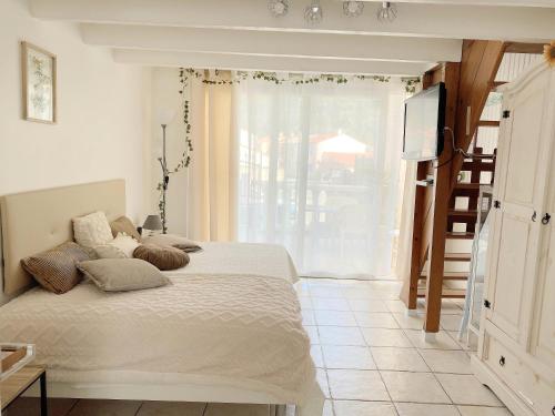 a bedroom with a bed and a tv and a window at Maisonnette proche Mer Terrasse Parking Climatisée in Villeneuve-Loubet