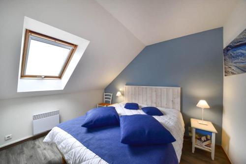 une chambre avec un grand lit avec des oreillers bleus dans l'établissement Port du Crouesty Cap'Océan - maeva Home - 3 Pièces 7 Personnes - Sélection - vue sur le Port MAE-1497, à Arzon