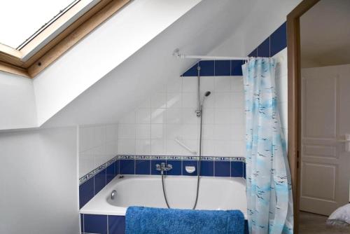 La salle de bains est pourvue d'une baignoire et de carrelage bleu et blanc. dans l'établissement Port du Crouesty Cap'Océan - maeva Home - 3 Pièces 7 Personnes - Sélection - vue sur le Port MAE-1497, à Arzon