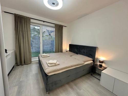 a bedroom with a bed with two towels on it at Klimatizovaný Apartmánový dom s vírivkou, 9A in Senec