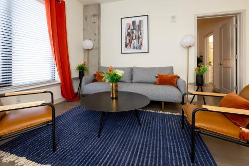 a living room with a couch and a table at Modern Nulu 2BR CozySuites 03 in Louisville