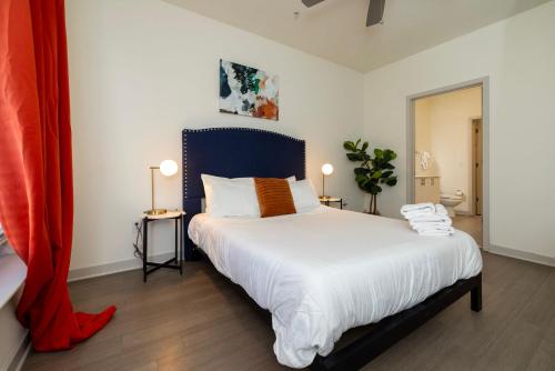 1 dormitorio con 1 cama grande y cabecero azul en Modern Nulu 2BR CozySuites Unit 03, en Louisville