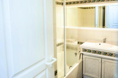 La salle de bains blanche est pourvue d'un lavabo et d'une douche. dans l'établissement Village Pont Royal en Provence - maeva Home - Appartement 2 Pièces 7 Personnes, à Mallemort