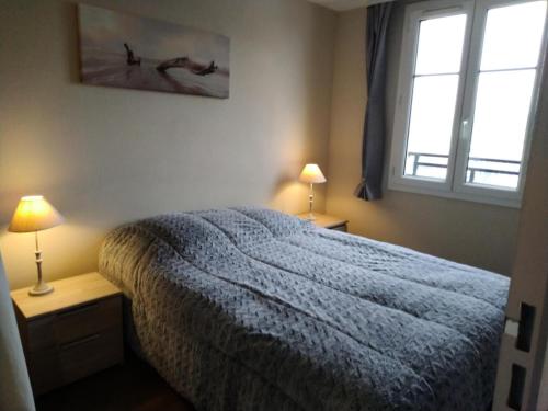 1 dormitorio con 1 cama, 2 lámparas y ventana en Résidence Port Guillaume - maeva Home - 3 Pièces 6 Personnes Confort 51, en Dives-sur-Mer