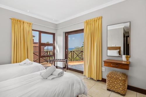a bedroom with two beds and a balcony at San Lameer Villa - 14328 - 4 Bedroom Deluxe - 8 pax - San Lameer Rental Agency in Southbroom