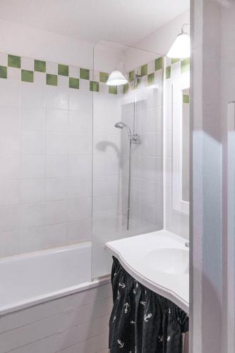 une salle de bain blanche avec un lavabo et une douche dans l'établissement Résidence Les Embruns - maeva Home - Studio 4 Personnes Confort MAE-1715, à Deauville