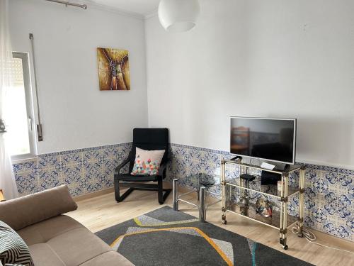 a living room with a couch and a tv at 2 Bedroom apartment in Caparica by the beach in Costa da Caparica