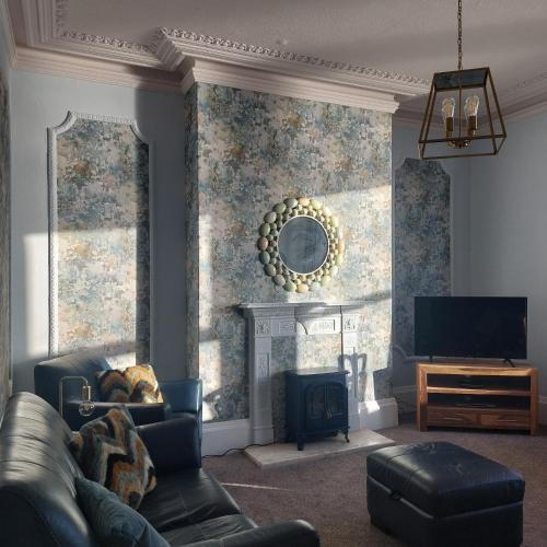 a living room with a couch and a fireplace at Brigg View Holiday Apartment in Filey