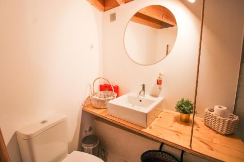 een badkamer met een wastafel, een spiegel en een toilet bij Macário Cosy Loft in Porto