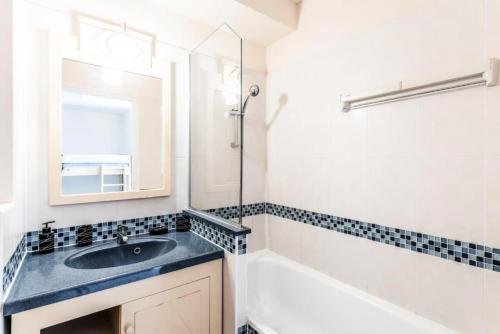 een badkamer met een wastafel, een bad en een spiegel bij Résidence Héliotel Marine - maeva Home - Studio 4 Personnes Confort 78 in Cros-de-Cagnes