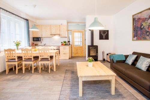 een woonkamer en een keuken met een tafel en een bank bij Ferienhäuser Ilsestein Doppelhaus, 100 qm, 3 Schlafzimmer in Ilsenburg