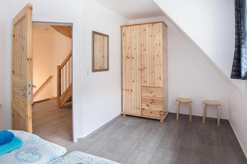 een kamer met een bed, 2 krukken en een trap bij Ferienhäuser Ilsestein Doppelhaus, 100 qm, 3 Schlafzimmer in Ilsenburg