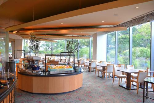 a restaurant with tables and chairs and large windows at Miyako Hotel Gifu Nagaragawa in Gifu