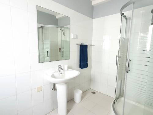 y baño blanco con lavabo y ducha. en Inviting 5-Bed Apartment in Luanda, en Luanda