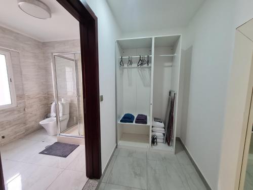 a white bathroom with a shower and a toilet at Lovely 5-Bed Suits - Guest House in Luanda in Luanda