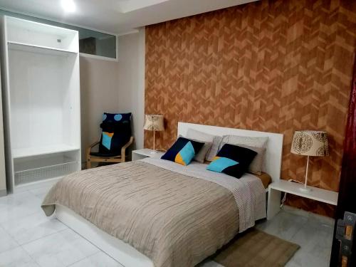 um quarto com uma cama grande e almofadas azuis em Lovely Guest House in Luanda em Luanda