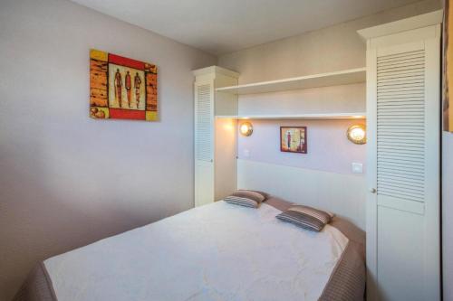 ein Schlafzimmer mit einem Bett mit zwei Kissen darauf in der Unterkunft Résidence Bleu Marine - maeva Home - 2 Pièces 4 Personnes Confort MAE-2045 in Lacanau