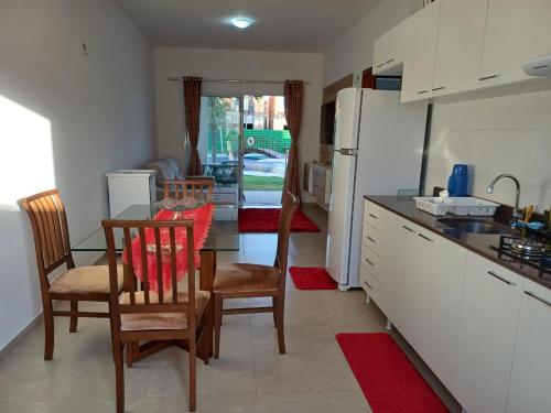 a kitchen with a table and chairs and a kitchen with a sink at Paraíso Canoa Quebrada in Canoa Quebrada