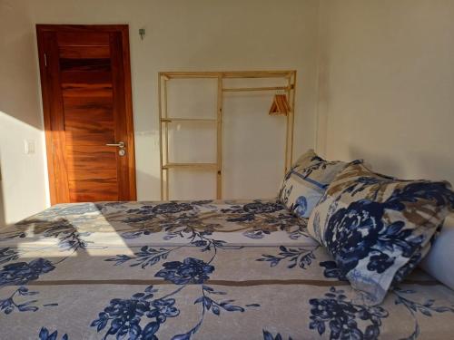 a bedroom with a bed with a blue and white comforter at Paraíso Canoa Quebrada in Canoa Quebrada