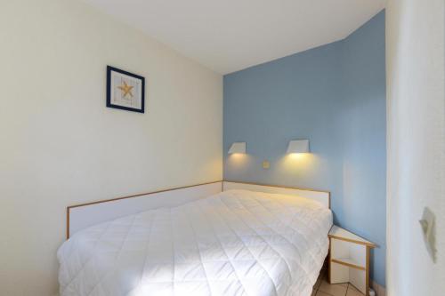 een slaapkamer met een wit bed in een kamer bij Résidence Port Bourgenay - maeva Home - Appartement 2 pièces 5 personnes - 48 in Talmont