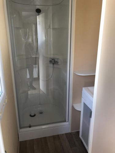 W łazience znajduje się prysznic ze szklanymi drzwiami. w obiekcie MOBIL HOME w mieście Vic-la-Gardiole