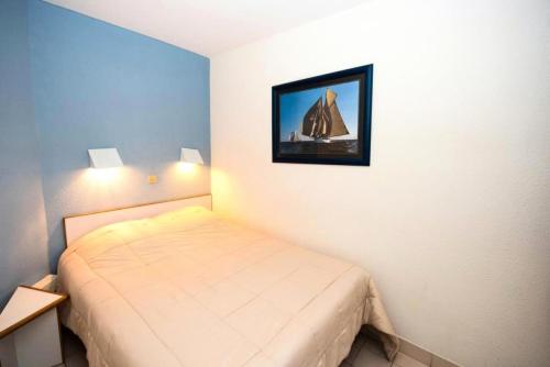 - une petite chambre avec un lit et une photo de bateau dans l'établissement Résidence Port Bourgenay - maeva Home - 2 Pièces 5 Personnes Sélection MAE-2053, à Talmont-Saint-Hilaire
