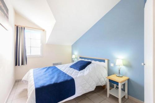 - une chambre bleue et blanche avec un lit et une table dans l'établissement Résidence Port Bourgenay - maeva Home - Appartement 2 Pièces 5 Personnes - Sélection MAE-2073, à Talmont-Saint-Hilaire