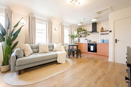 ein Wohnzimmer mit Couch und Küche in der Unterkunft Cosy Studio Steps From Beach in Weymouth