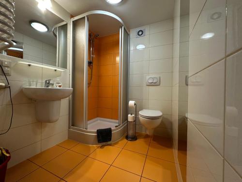 y baño con ducha, aseo y lavamanos. en Kompleks Apartament-Serwis, en Cracovia