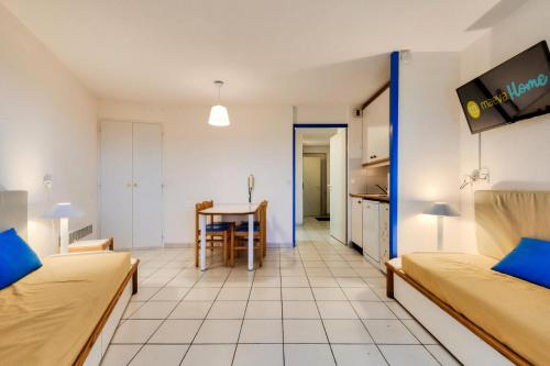 un salon avec deux lits et une table dans l'établissement Résidence Port Bourgenay - maeva Home - Appartement 2 Pièces 4 Personnes - Sélection MAE-2054, à Talmont-Saint-Hilaire