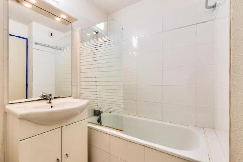 y baño blanco con lavabo y bañera. en Résidence Port Bourgenay - maeva Home - Appartement 2 Pièces 4 Personnes - 54, en Talmont