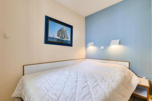 une chambre avec un lit et un tableau au mur dans l'établissement Résidence Port Bourgenay - maeva Home - 2 Pièces 5 Personnes Sélection MAE-2081, à Talmont-Saint-Hilaire