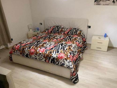 un letto con un piumone colorato in una camera da letto di Il B&B di Francesco a Castano Primo