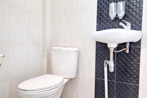 a bathroom with a toilet and a sink at Homestay Dalimo 2 Syariah RedPartner in Payakumbuh